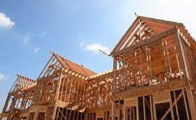 House under construction with blue skies.