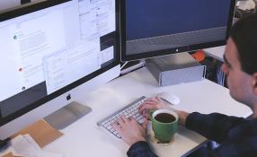 This is an image of a man looking at his computer screen