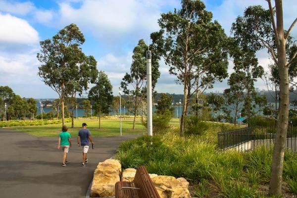 Image of people walking in a native park area with trees