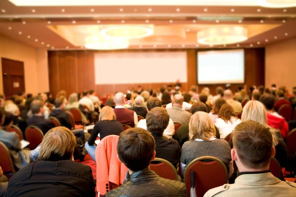 Image from behind an audience of community members attending a meeting or presentation