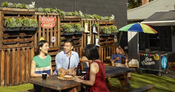 three people enjoying lunch outdoors at a pub