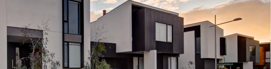 Image of modern residential homes with clouded sunset in background