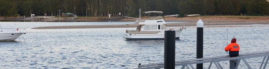 This is an image of a man fishing on a wharf