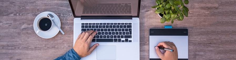 This is an image of a man with a laptop taking notes